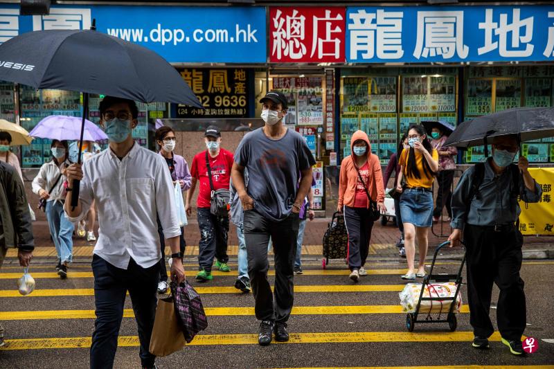 图为3月28日香港街头戴口罩的市民.(法新社)
