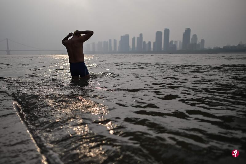 一名男子准备在流经武汉市的长江支流游泳.(法新社)