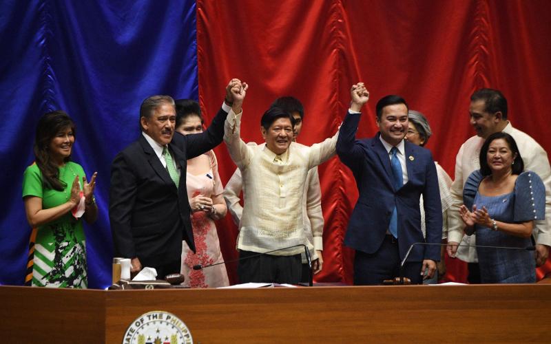 菲律宾国会参众两院周三召开联席会议，正式宣布小马可斯（中）在本月初举行的总统选举中获胜，当选菲律宾第17任总统。左一为小马可斯的参议员姐姐艾米，右一为他的妻子丽莎。（法新社）