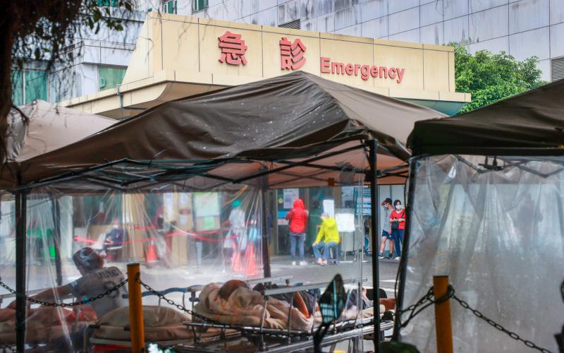 台湾疫情进入估计为期一个月的高原期，医护人力也越来越吃紧。新北市一家医院昨天在急诊室外搭起临时病床，收治紧急和病危的病患。（中通社）