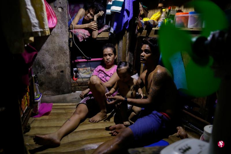 伴侣和孩子挤在马尼拉通多贫民窟的棚屋内